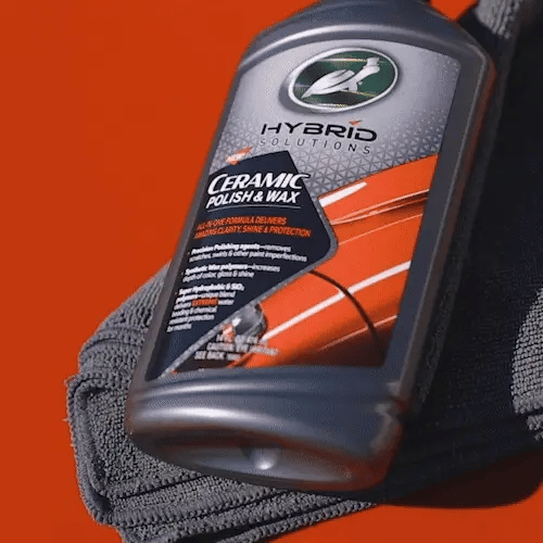Hybrid Solutions ceramic polish and wax bottle with a towel on an orange background
